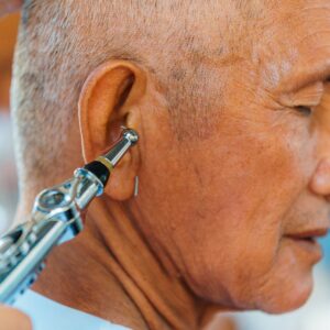 Close-up of a man’s ear during a medical ear examination using an otoscope.